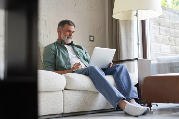 Man on couch looking at laptop
