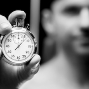A close-up of a stopwatch held by a man, representing the therapeutic goal of increasing the pause between impulse and action.